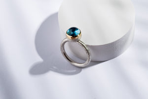 Silver ring with gold details & topaz stone.