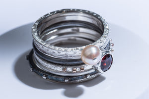 Set of seven silver rings with gold details, garnet stone & pearl